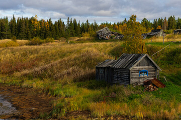 wooden old house on the river, far outside the city, Murmansk region in autumn, copyspace, landscape