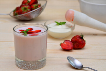 yogurt with strawberries a glass of strawberry yogurt and ingredients for making it berries and dairy products