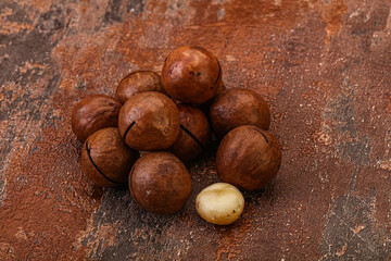 Brown macadamia nut heap over background