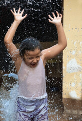 Child playing in the yard with water in the Brazilian summer. selective focus.
