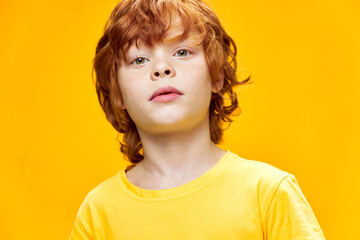 Little redhead boy close-up yellow t-shirt 