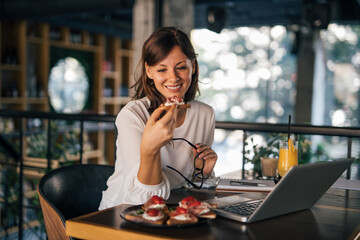 Business woman eating at restaurant.