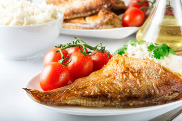 Sea bass grill with rice, greenery and cherry tomatoes. White background.