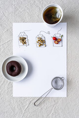 Drei selbst gezeichnete Teebeutel mit getrockneten Kräutern und Früchten. Ein Pappbecher Tee und ein Schokolade Donat auf einem weißen Hintergrund. Flat lay.