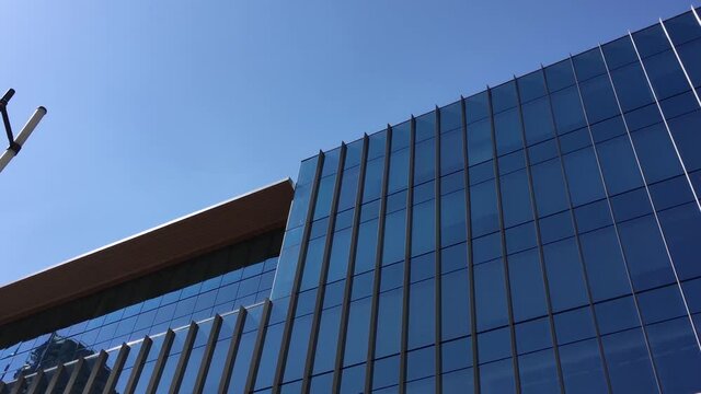 One side of modern business building glasses with reflections in downtown Vancouver BC Canada.