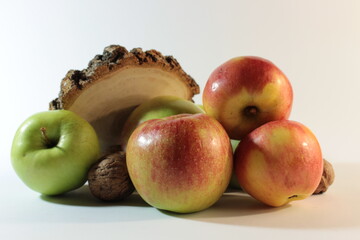 Apples and walnuts on a wooden stump
