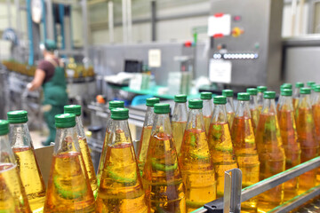 apple juice in glass bottles in a factory for the food industry - bottling and transport