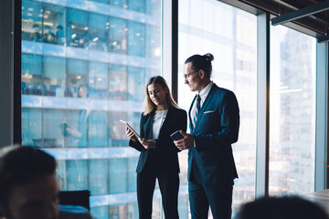 Business partners in modern office watching presentation on tablet