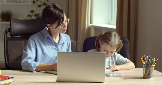 Happy family mother baby sitter teaching cute child girl playing studying at desk at home, mom helping kid daughter learning drawing coloring with pencils and markers together enjoy creative activity