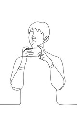 young man holds his smartphone horizontally he is distracted and looks to the side. one line drawing concept of interruption of online surfing, watching video / broadcasting, shooting video