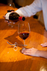 女性のグラスにワインを注ぐ男性