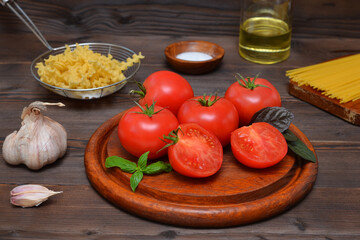 still life with ripe tomatoes and pasta on a dark wooden background ingredients for making spaghetti sauce