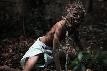 Scary scarecrow crawling in dark forest. Halloween background