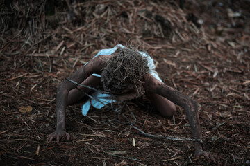 Scary scarecrow crawling in dark forest. Halloween background