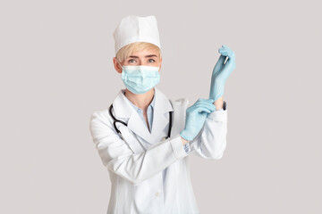 Fototapeta premium Reception and examination by doctor and modern treatment in clinic. Middle aged woman puts on rubber gloves
