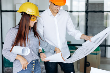 A team of engineers work in the office, reviewing drawings