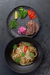 Traditional vietnamese pho bo soup in dark plate