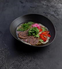 Traditional vietnamese pho bo soup in dark plate