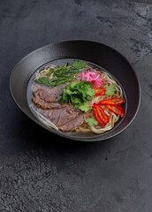 Traditional vietnamese pho bo soup in dark plate