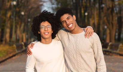 Two african guys hugging over park background