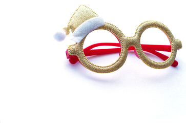 fashion accessory, holiday glasses with sequins and a Christmas hat. Bright, shiny glasses lie on a white surface. Place for text, inscriptions. Leisure, winter, Christmas holidays, new year. Glasses 