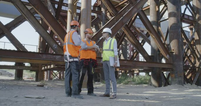Builders talking near metal structure