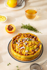 Delicious chiffon cake with custard cream and nectarines with herbal tea and thyme on light...