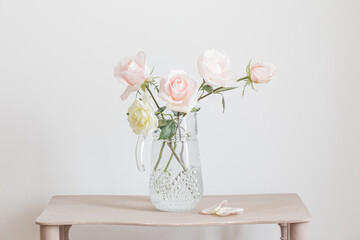 beautiful roses in glass jug on white background