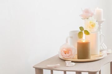 Fototapeta na wymiar beautiful roses and burning candles on white background