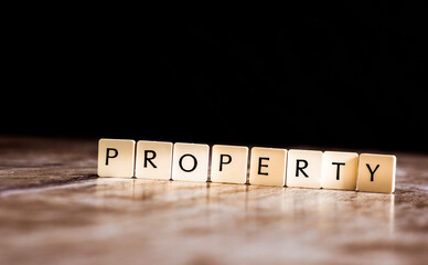 Property word made of tiles on dark wooden background