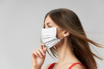 Woman medical mask on face side view light background 