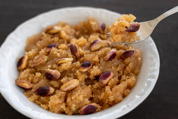 semolina halva. Turkish dessert; irmik helvası with pistachio on wooden background