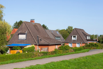 Fototapeta na wymiar Wohnhäuser, Einfamilienhäuser am Deich im Grünen, Grolland, Bremen, Deutschland