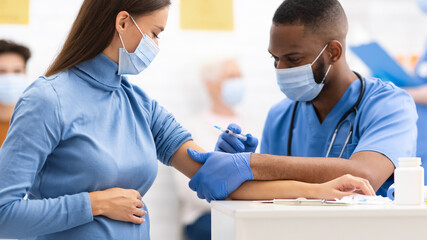 Doctor Injecting To Pregnant Woman Covid-19 Medicine Injection In Clinic