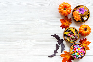 Halloween holiday background with pumpkins, cookies and autumn leaves, top view