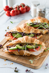 Close up of croissant sandwiches against a sunny window.
