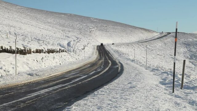 Traffic crossing the pass over the Lecht in Scotland during winter.