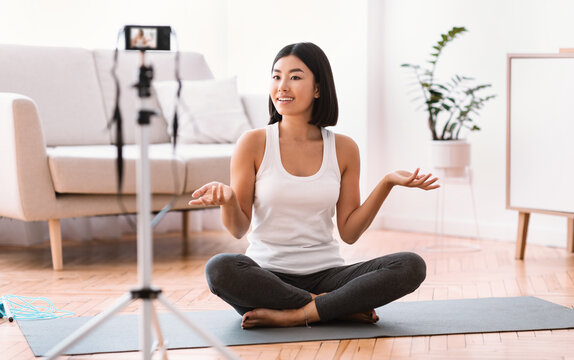 Sporty asian woman filming exercises for home training - Powered by Adobe