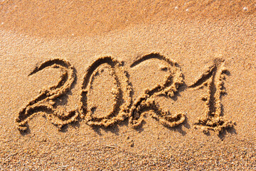 2021 written on a sandy beach. Summer holidays in 2021