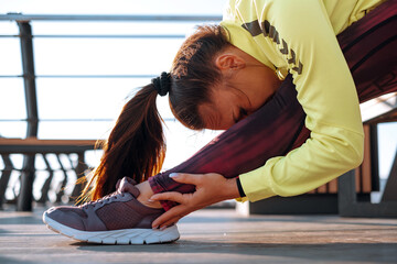 outdoor workout concept. young woman in tracksuit performs sports workout on the pier
