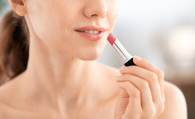 Cropped of woman using lipstick, copy space