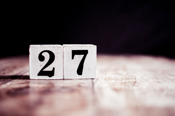 Number 27 isolated on dark background- 3D number twenty seven isolated on vintage wooden table