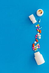 Medical pills and tablets spilling out of bottle, copy space