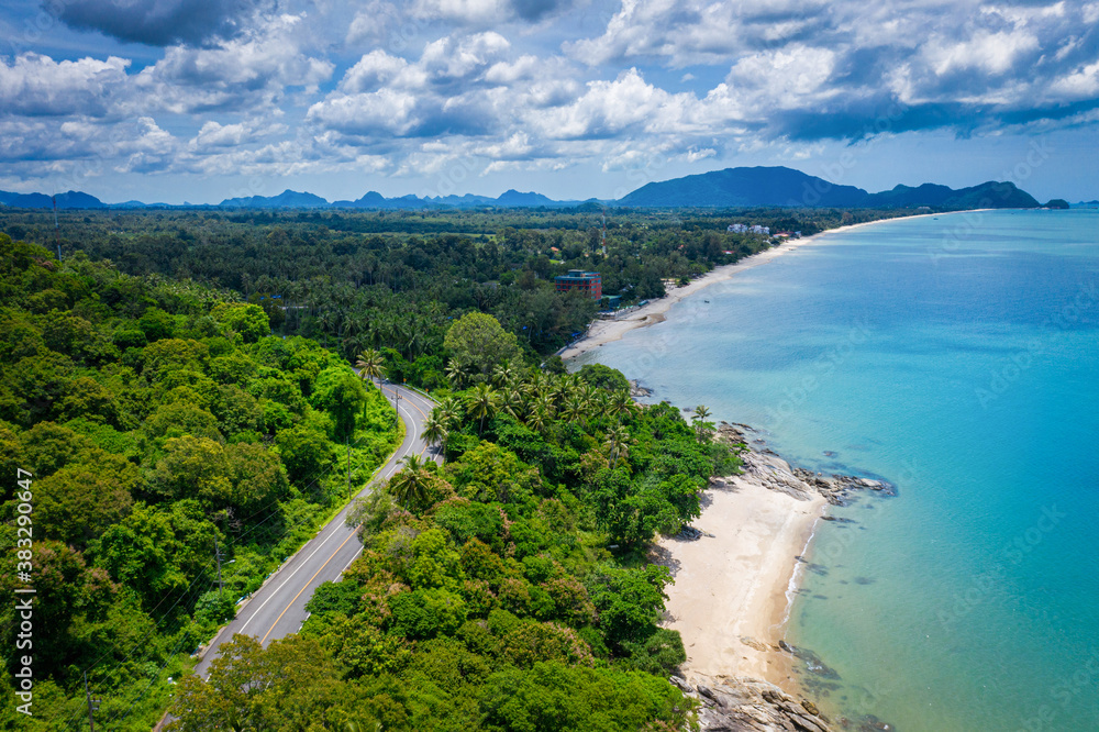 Wall mural aerial view of road between coconut palm tree and great ocean at daytime in nakhon si thammarat, tha