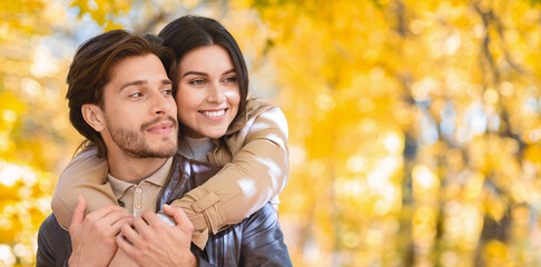 Woman in love hugging her man from behind, forest background