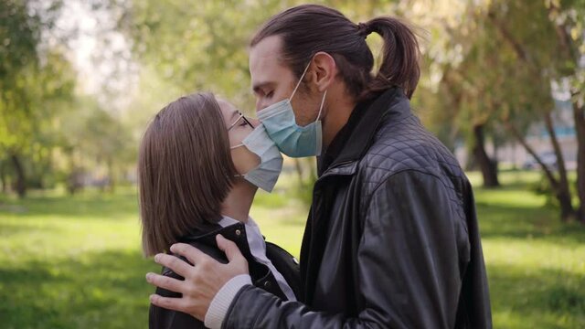 Meeting a young couple on the street and kissing them in a protective medical face mask. Coronavirus lifestyle and prevention.