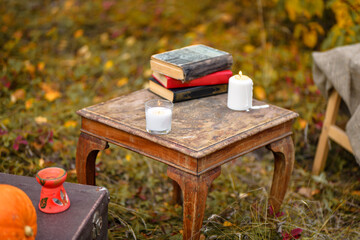 Halloween. Autumn background. Place for magic: candles, pumpkin, old books of witchcraft, an old...