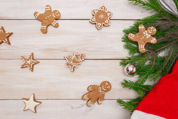 Two gift boxes with red ribbons on a light wooden background,ginger shaped cookies and Christmas tree branches. Concept of New Year and Christmas, gifts, holiday. Top view.