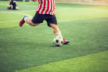 Fat kid soccer player run to shoot ball to goal on artificial turf. Soccer player training for...