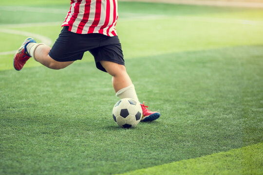 Fat kid soccer player run to shoot ball to goal on artificial turf. Soccer player training for football match.